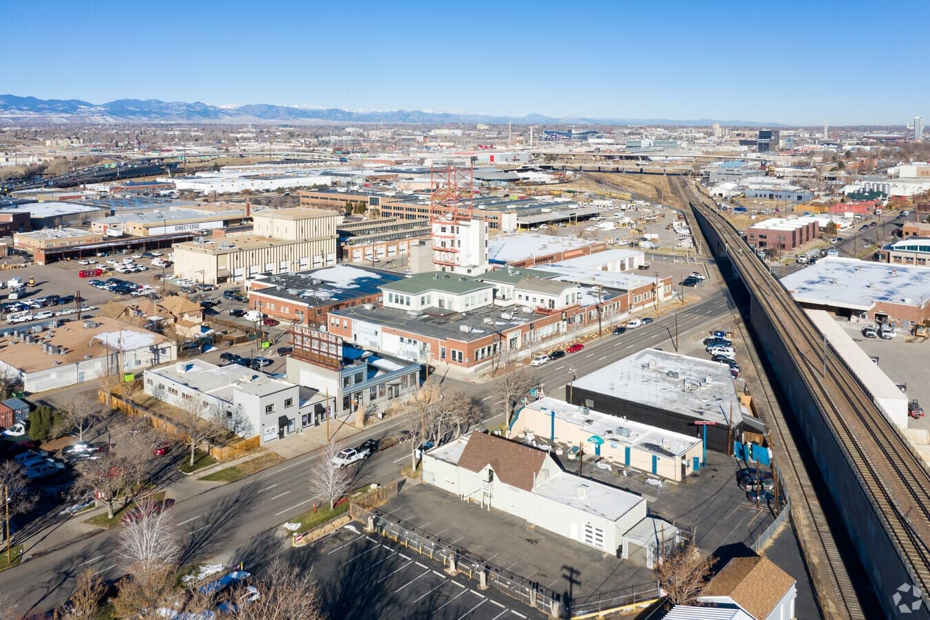 Aerial view of photospace in Denver — the studio, the rail line, and the Rockies on the horizon